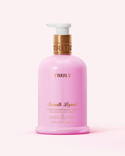A pink bottle of Truly Beauty Hydra-Renew Body Wash, 15 fl oz (443 mL), with a gold and white pump, gold lettering, sits against a light pink background.