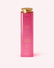 A bright pink cylindrical bottle with a gold cap, labeled Truly Beauty The Clearing Body Serum, 3.1 fl oz (90 mL), stands upright against a light pink background.