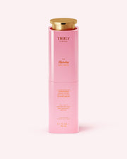 A pink cylindrical bottle with a gold cap labeled Truly Beauty The Hydrating Body Serum stands upright on a plain background. This 3.1 FL OZ (90 mL) serum is infused with hyaluronic acid for intense hydration.