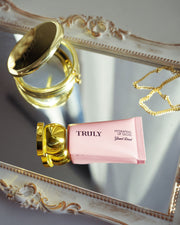 Pink lip gloss with gold cap on a decorative surface