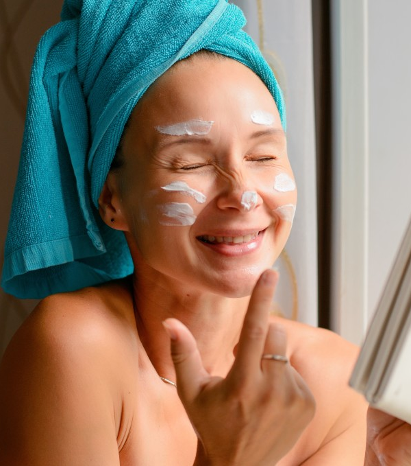 woman in head towel with splotches of face cream