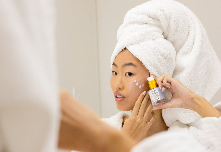 hydrafacial at home | woman holding truly's glass skin facial serum next to face