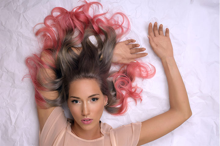 woman lying down with pink hair spread out