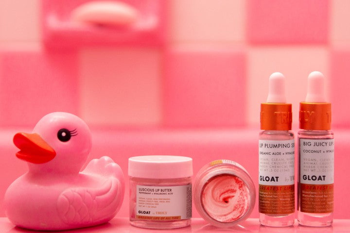 Truly Beauty gloat lip products with pink bathroom tile background