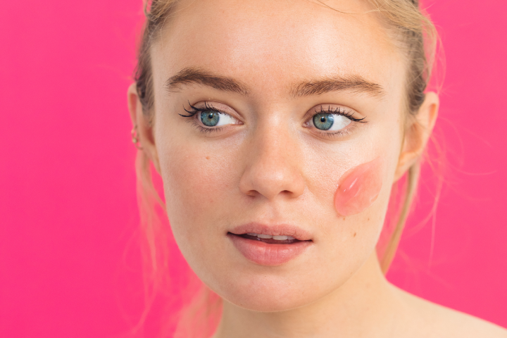 Young woman looking to the side with gel mask swatch on cheek
