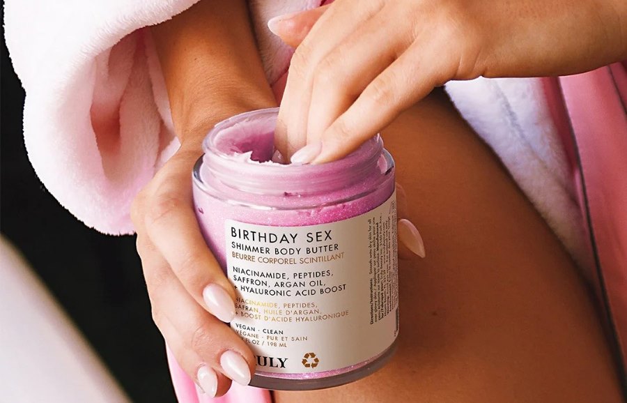 niacinamide and salicylic acid | closeup of woman's hand in jar of Truly's birthday sex body butter