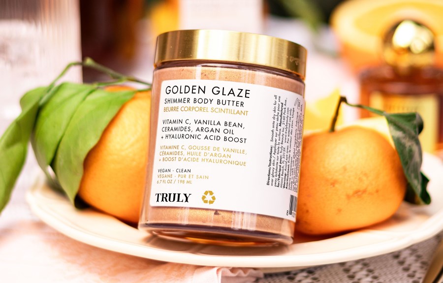 ceramides for skin | truly's golden glaze shimmer body butter on plate with oranges