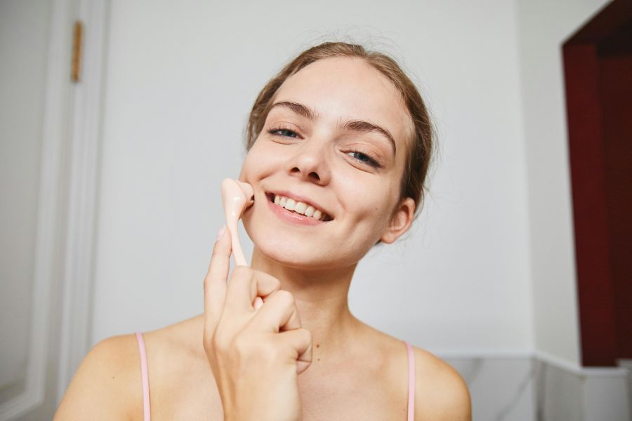 A young woman massaging her face | how to get rid of a puffy face