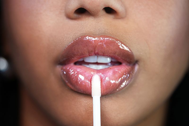 How to Heal Cracked Lip Corners Fast | closeup of woman with glossy plump lips applying lip oil