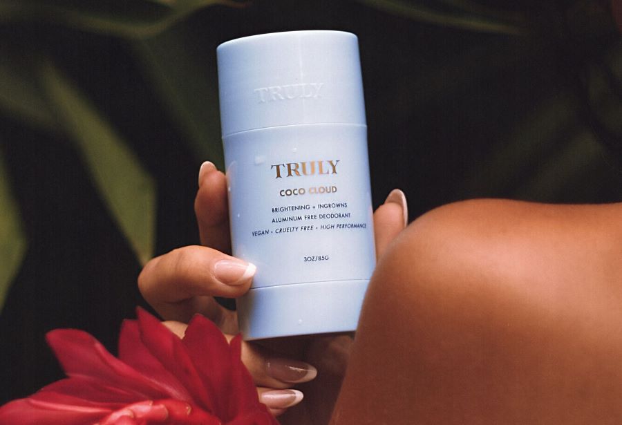 ingrown deodorant | Woman holding Truly's coco cloud deodorant