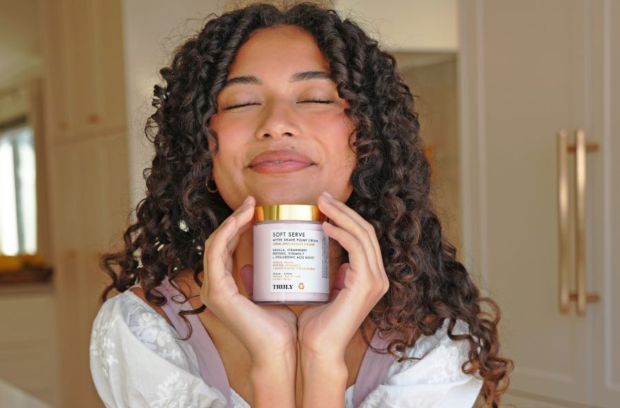 Young woman with closed eyes holding Soft Serve After Shave Cream in front of her face