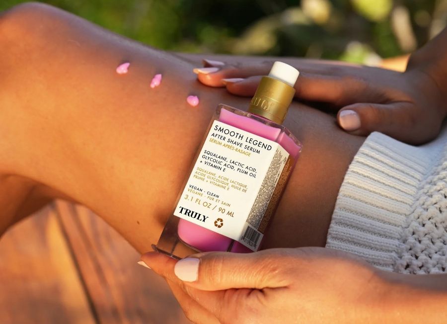 what is the best kp treatment | Closeup of woman's smooth leg holding Truly Smooth Legend Serum with lactic acid and glycolic acid 