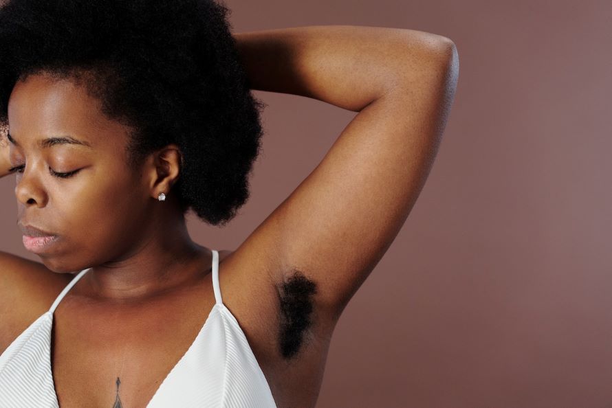 Why does my body hair grow so fast | Woman with arm behind head revealing hairy underarm