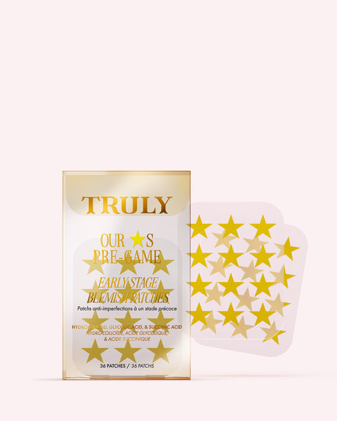 A package labeled Truly Beauty Our Stars Pre-Game Blemish Patches features a gold, star-themed design. Next to it is a clear sheet with multiple gold, star-shaped hydrocolloid patches infused with tea tree oil.