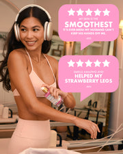 A smiling woman in a peach sports bra and leggings applies Truly Beauty’s Smooth Legend After Shave Serum to her arm while wearing large headphones. Two pink review bubbles praise it for smoothing skin and improving strawberry skin.