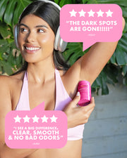 A smiling woman in headphones raises her arm, holding Truly Beauty's Unicorn Fruit Skin Brightening and Smoothing Deodorant. Two pink starbursts feature testimonials praising its aluminum-free formula and brightening underarm effects.