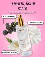 A bottle of Diamond Baby Treatment Body Serum by Truly Beauty is displayed with black currant berries, a white vanilla crème flower, and a white jasmine flower, highlighting its notes of black currant, vanilla crème, and midnight jasmine.