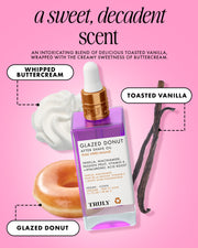 A bottle of Truly Beauty Glazed Donut After Shave Oil—ideal for post-shave hydration—sits among whipped buttercream, a glazed donut, and vanilla beans on a pink backdrop, with text highlighting its sweet, decadent scent.