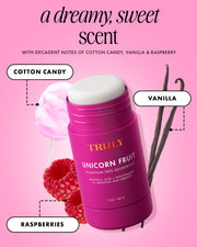 A bright pink, aluminum-free Unicorn Fruit Skin Brightening and Smoothing Deodorant by Truly Beauty is displayed with cotton candy, vanilla beans, and raspberries on a pink background. Text highlights its scent notes: cotton candy, vanilla, and raspberries.