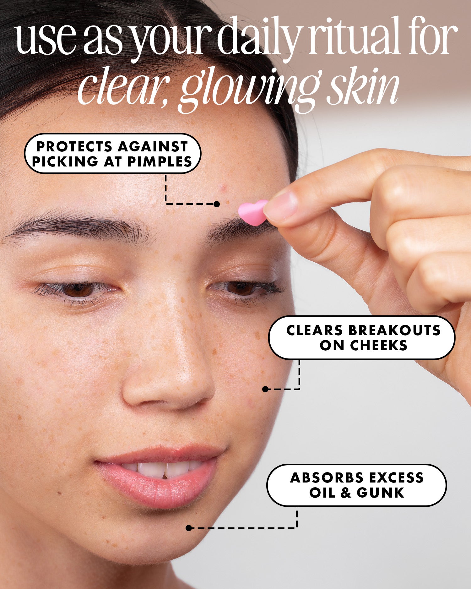 A woman holds a #Heart Your Imperfections Blemish Patch by Truly Beauty near her face. These hydrocolloid patches protect against picking, absorb excess oil and gunk, and help clear breakouts for glowing skin.