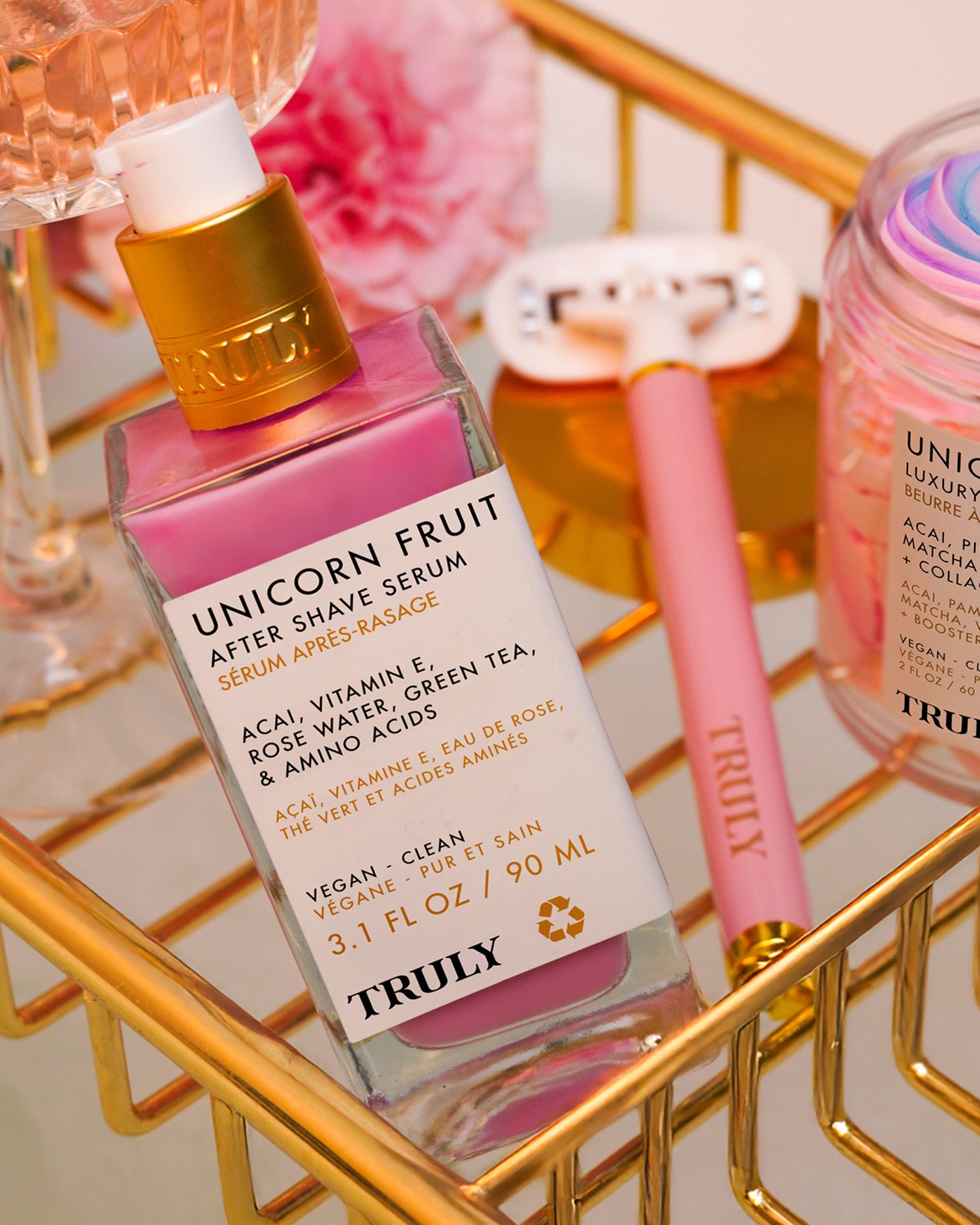 Unicorn Fruit after shave serum bottle on a gold tray with pink and gold accents.