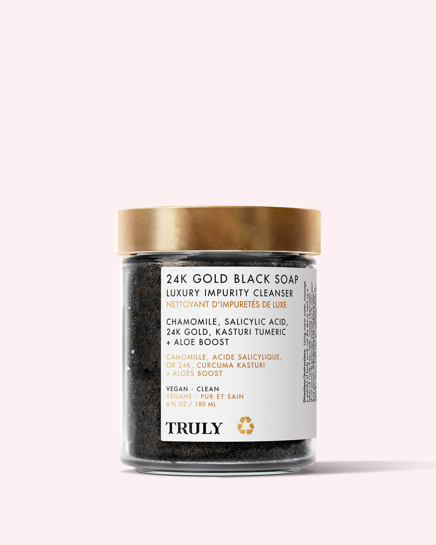 A glass jar of 24K Gold Black Soap Luxury Impurity Cleanser by Truly Beauty, with a gold lid and label noting anti-aging ingredients such as chamomile, salicylic acid, 24K gold, turmeric, and African black soap.