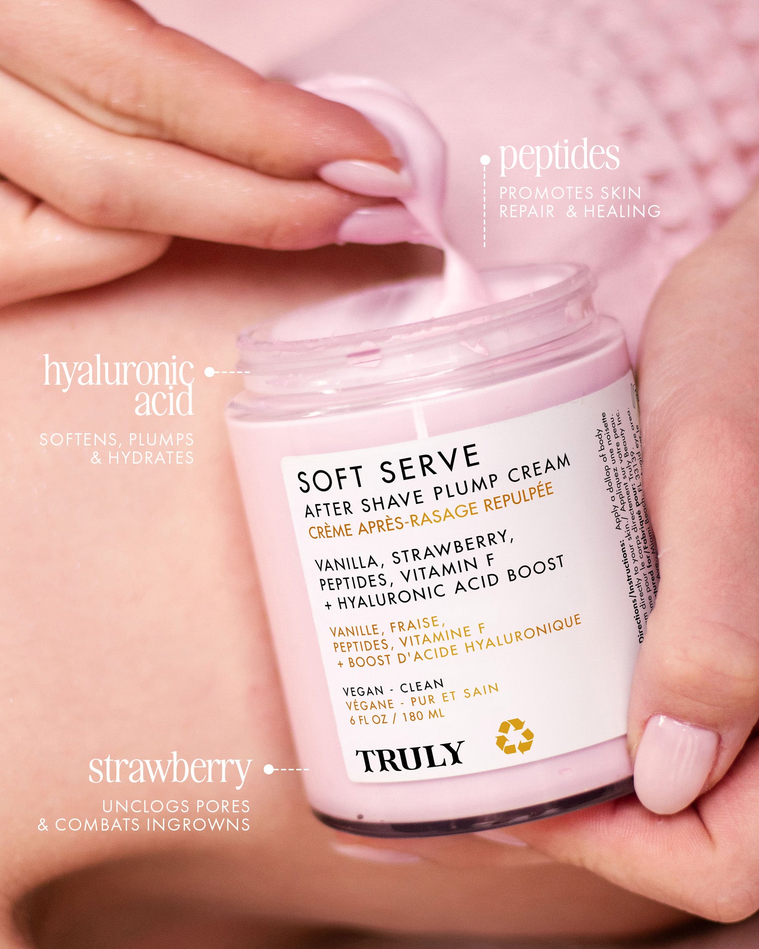 A hand holds an open jar of Truly Beauty’s Soft Serve After Shave Plump Cream, revealing its pink, hydrating formula. Peptides, hyaluronic acid, and strawberry are featured for skincare benefits and reducing ingrowns.