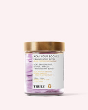 A glass jar of Truly Beauty Acai Your Boobies Butter with a gold lid, featuring acai and retinol on the label. This whipped formula has swirled purple and white hues for smoother-looking skin.