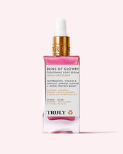 A pink and gold dropper bottle of Buns Of Glowry Tightening Body Serum by Truly, featuring ultra-hydrating serum with watermelon, vitamin E, apricot, orange flower, and wheat protein extract on a light pink background.