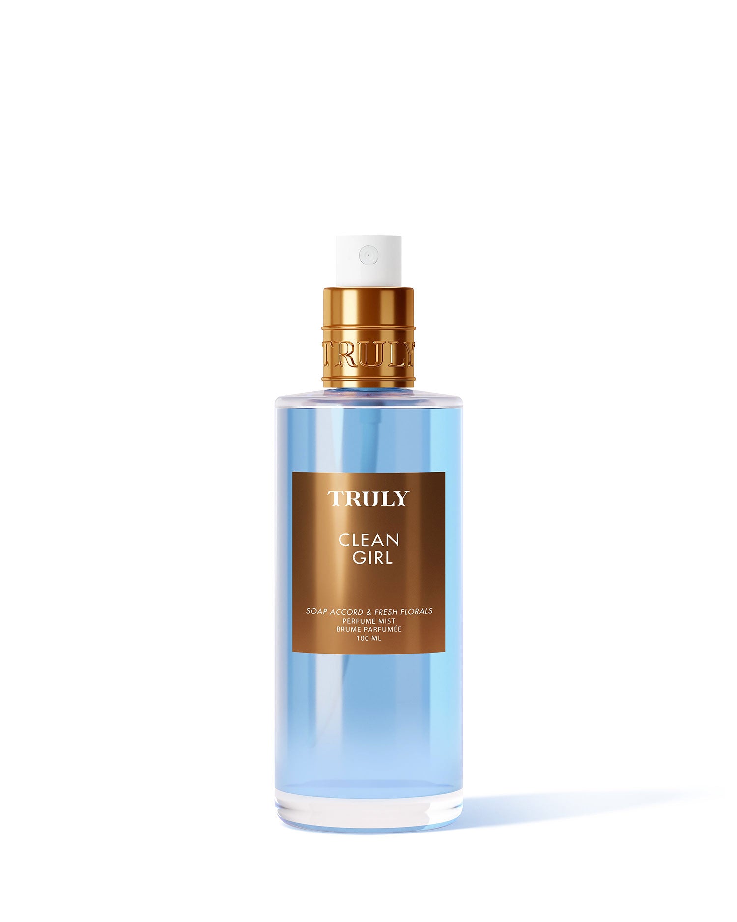 A clear spray bottle with blue liquid labeled Clean Girl Perfume Mist by Truly Beauty, topped with a gold cap, stands on a light pink background; this fragrance blends fresh florals with white musk.