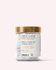 A clear jar with a gold lid contains Coco Cloud Luxury Shave Butter by Truly Beauty, made with coconut milk, vanilla, and argan oil to smooth skin and reduce ingrown hairs.