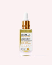 A clear dropper bottle of Cooka Oil by Truly Beauty for pubic hair and skin, featuring lavender, tea tree, jojoba, and primrose oils. The vegan, clean formula is antimicrobial and designed to help prevent ingrown hairs.