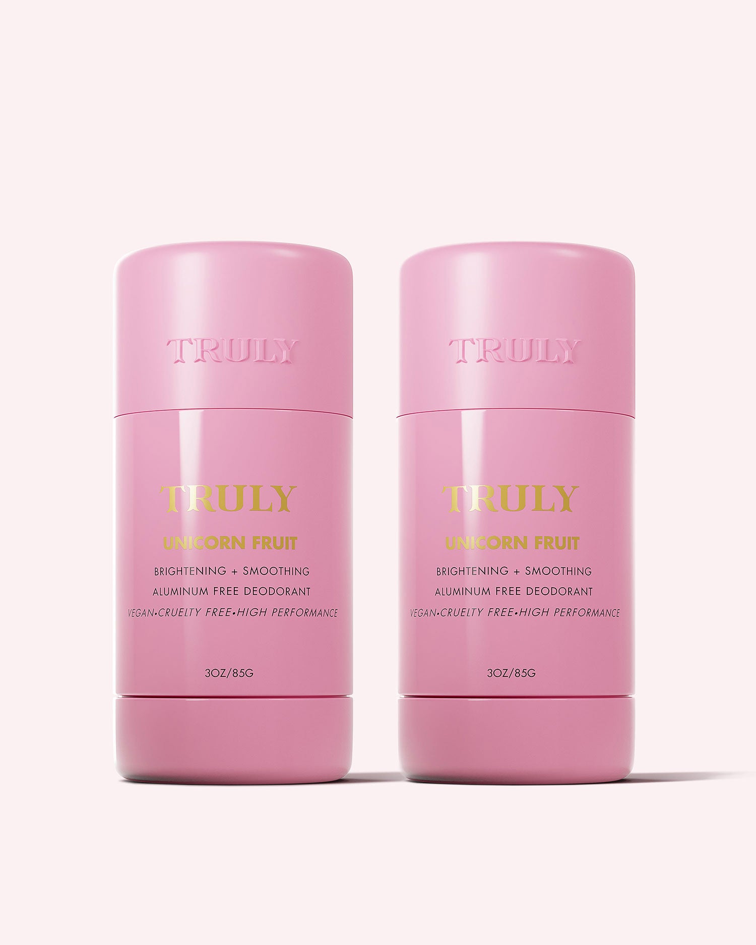 Two pink TRULY BEAUTY Unicorn Fruit Skin Brightening and Smoothing Deodorant sticks stand side by side on a light pink background. This 2-pack offers aluminum-free, vegan deodorants that help address underarm discoloration and keep you fresh.