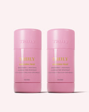 Two pink TRULY BEAUTY Unicorn Fruit Skin Brightening and Smoothing Deodorant sticks stand side by side on a light pink background. This 2-pack offers aluminum-free, vegan deodorants that help address underarm discoloration and keep you fresh.