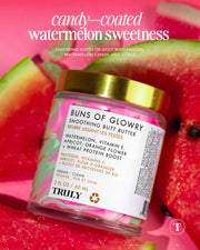 A jar of Truly Beauty’s Buns of Glowry Smoothing Butt Butter with a pink and gold lid sits among watermelon slices. Text above showcases watermelon, Wheat Protein, and more for smooth, glowing skin.