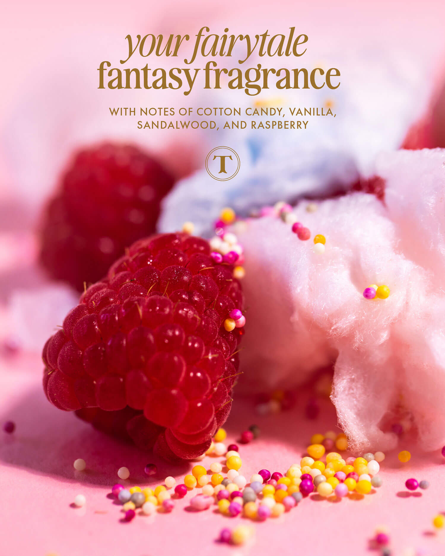 Close-up of raspberries, blue and pink cotton candy, and colorful sprinkles on a pink surface. Text above reads: Unicorn Fruit Duo by Truly Beauty—your fairytale fantasy whipped body butter with notes of cotton candy, vanilla, sandalwood & raspberry.