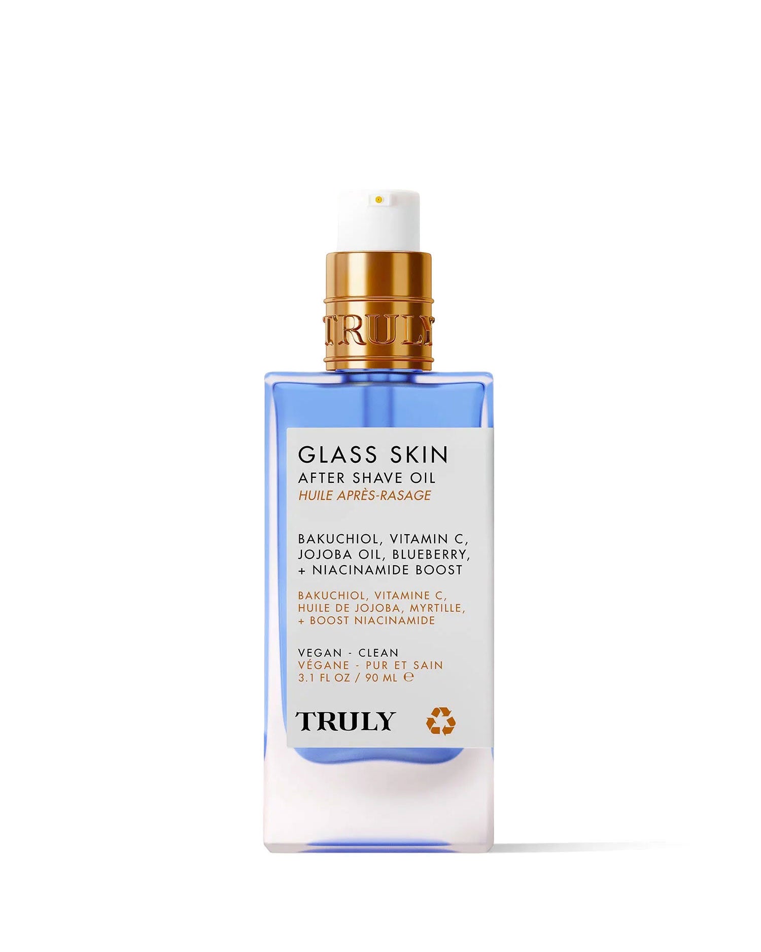 A clear bottle of Truly Beauty’s Glass Skin After Shave Oil with a blue base and gold pump. The label features bakuchiol, vitamin C, jojoba oil, blueberry, and niacinamide for a vegan, clean formula that delivers glass skin.
