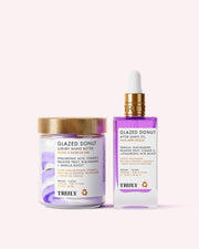 The Glazed Donut Duo by Truly Beauty includes a hydrating Shave Butter in a jar with a gold lid and a Shave Oil in a clear dropper bottle, both with purple and white accents.