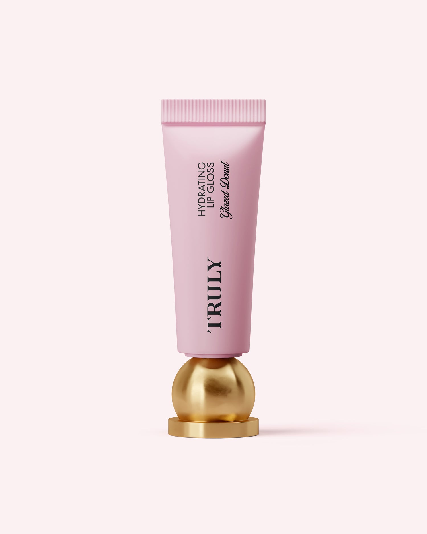 A pink tube of Truly Beauty Hydrating Lip Gloss with hyaluronic acid stands upright on a round, gold base against a light pink background.
