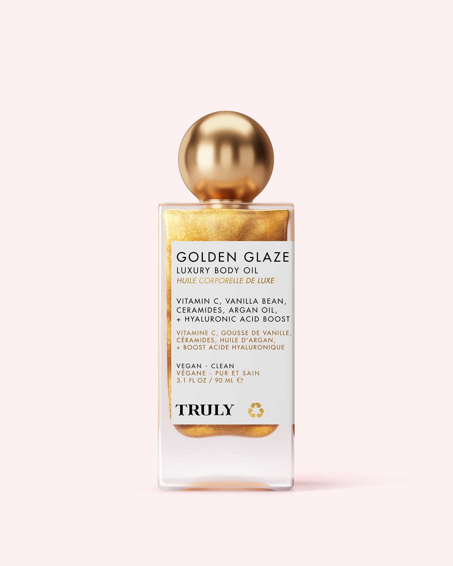 A bottle of Truly Beauty’s Golden Glaze Luxury Body Oil with a gold cap and shimmering liquid, featuring vitamin C, vanilla bean, ceramides, argan oil, and hyaluronic acid for radiant, hydrated skin.