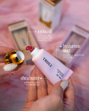 Lip balm with visible ingredients and 'TRULY' branding on a blurred background