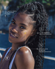 A woman with braided hair smiles outdoors as graphics highlight Truly Beauty’s Our Stars Prevent Scars Blemish Patches on her cheek, featuring a hydrocolloid formula with tea tree oil to cover blemishes and prevent acne scars and hyperpigmentation.