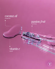 A glass dropper with clear Glazed Donut After Shave Oil on a pink surface, labeled to highlight coconut oil (hydrates), passion fruit (softens), and vitamin E (heals) for smooth, soft skin—ideal as a hydrating shave serum.