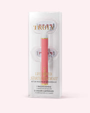 A pink razor kit in clear packaging, labeled Life Shaver Starter Razor from Truly Beauty. Made for sensitive skin, it includes a razor handle and two 5-blade cartridges. Set against a light pastel pink background.
