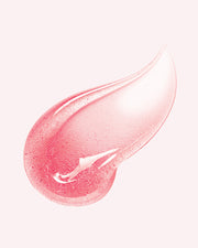 A close-up of The Luxury Peptide Lip Oils by Truly Beauty, featuring a pink, translucent swatch with a smooth, glossy texture on a light background.