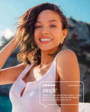 A smiling woman with short brown hair and a heart sticker on her cheek stands outdoors in sunlight, wearing a sleeveless white top. A testimonial for Truly Beautys #Heart Your Imperfections Blemish Patches appears at the bottom right.