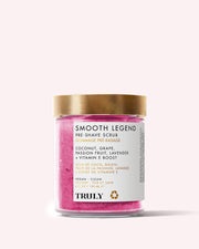 The Smooth Legend Pre-Shave Scrub by Truly Beauty comes in a pink jar with a gold lid and white label, featuring clean, vegan ingredients like coconut, grape, passion fruit, lavender, and Vitamin E for glowing skin.