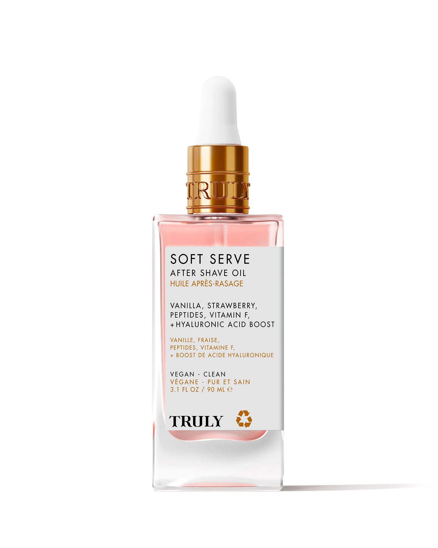 A glass dropper bottle of Soft Serve After Shave Oil features a gold cap, clear pink liquid, and a white label listing ingredients like vanilla, strawberry, peptides, vitamin F, and hydrating hyaluronic acid.