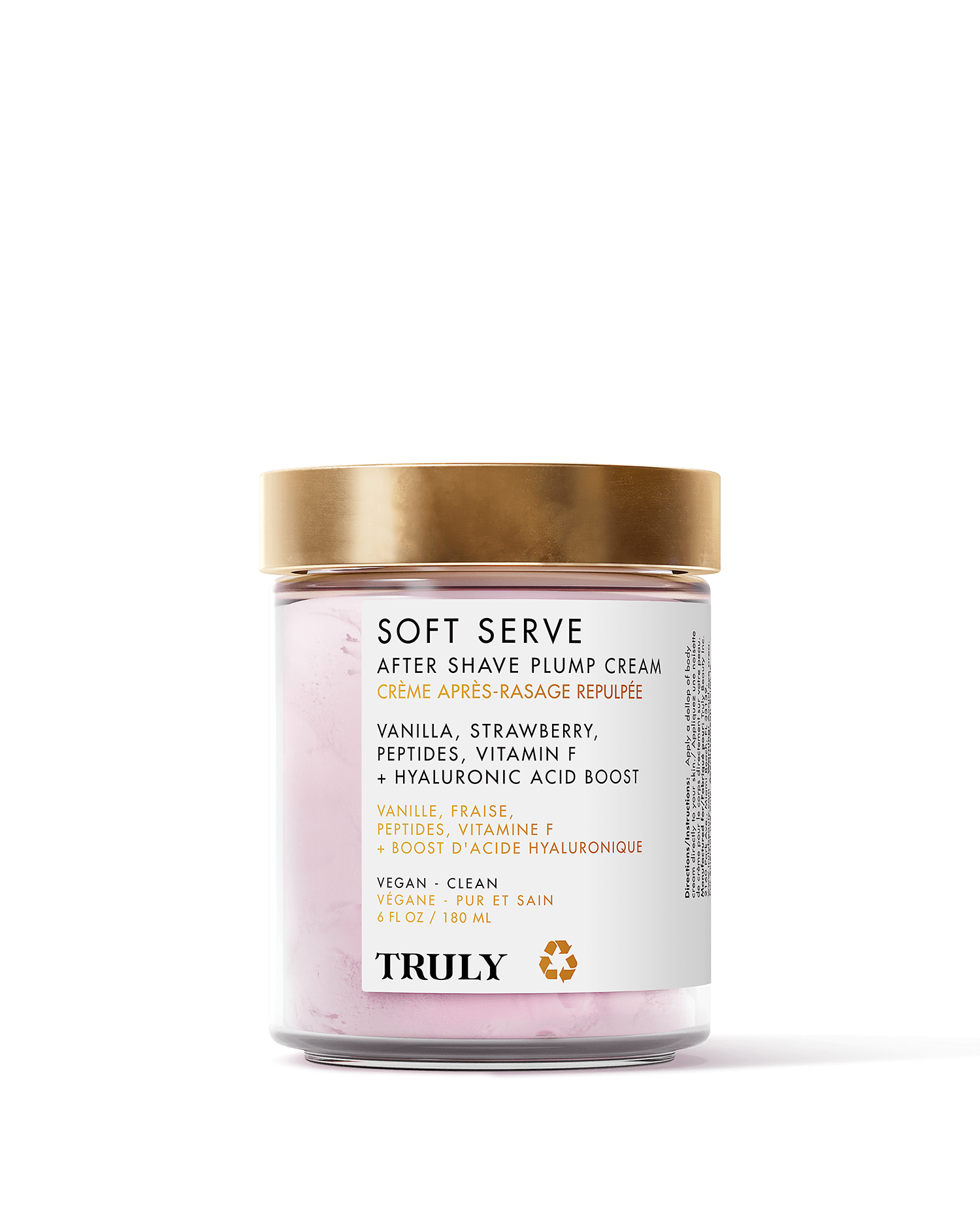 A glass jar with a gold lid labeled Truly Beauty Soft Serve After Shave Plump Cream showcases ingredients like vanilla, strawberry, peptides, vitamin F, and hyaluronic acid. The cream inside is light pink.