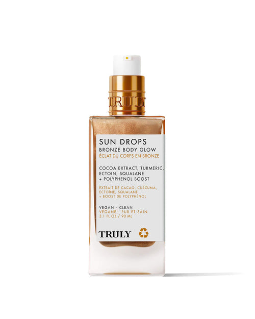 A 3.1 fl oz Sun Drops Bronze Body Glow by Truly Beauty, a hydrating bronzing oil with cocoa extract, turmeric, and squalane. Features a gold pump, white label with gold text, and delivers a sunkissed glow.